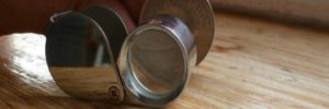 awesome guide to coin grading in 3 simple steps banner showing coin and loupe